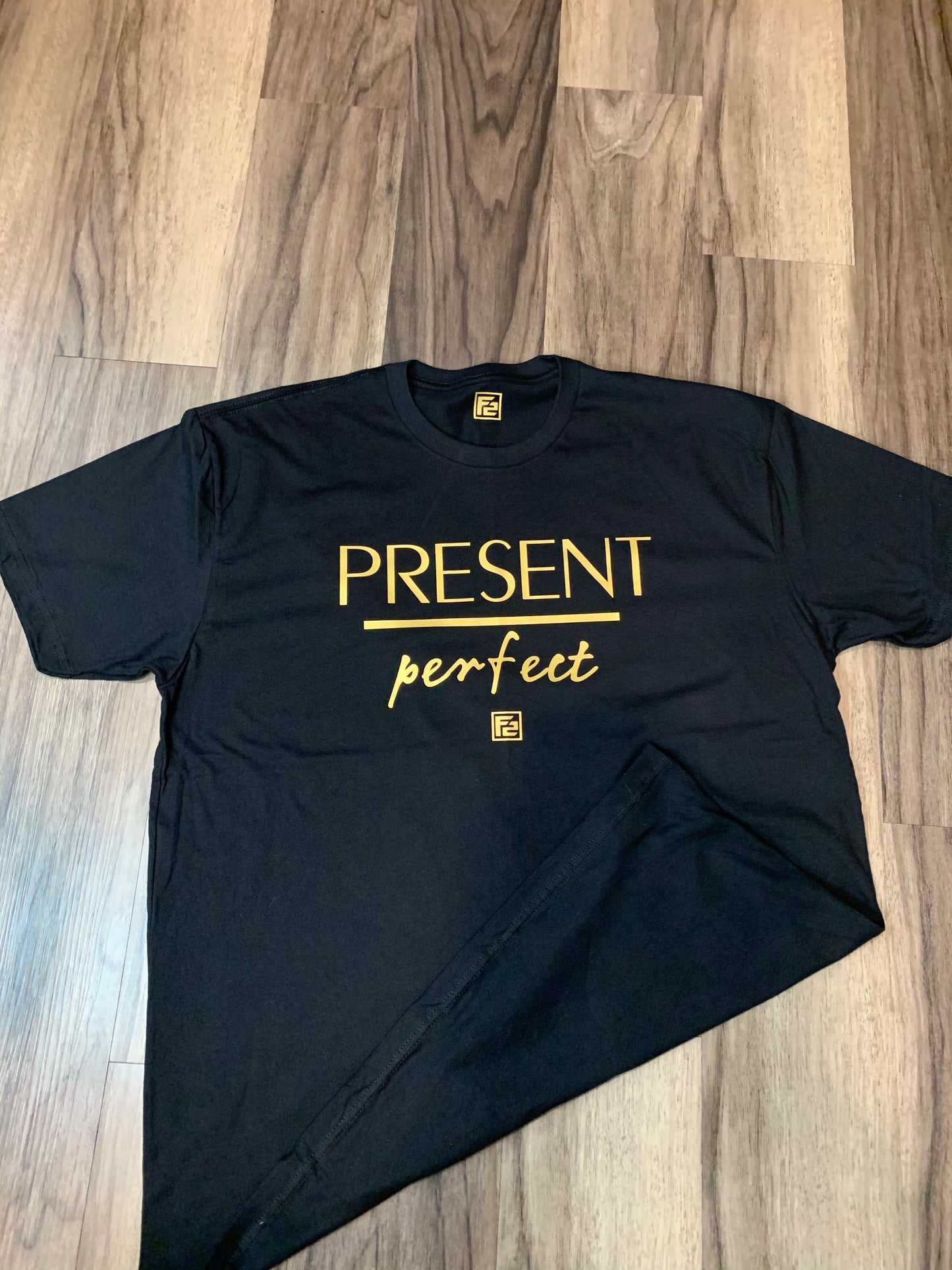 Stylish F2 Gold Present over Perfect Tee featuring bold gold script on a classic, comfortable crew neck design.