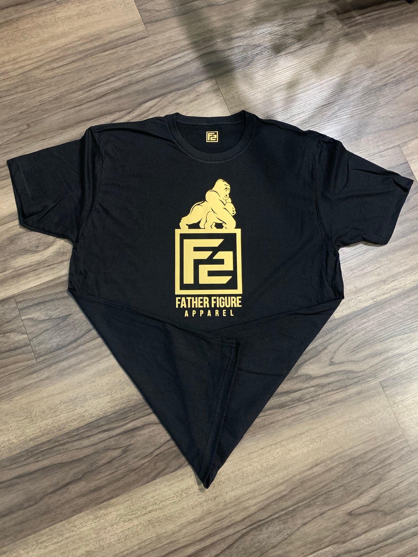 Stylish F2 Gold “Protector” Tee in a classic crew neck, featuring a bold logo symbolizing strength and fatherly protection.