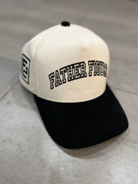 A cream-colored baseball cap with black corduroy brims and text that reads 'Father Figure' on the front.